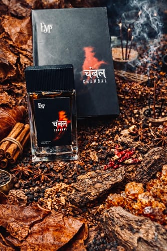 Customer's Chambal perfume bottle and box styled with dark, earthy spices, wood, and smoking incense.