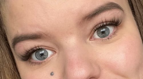 Kundin zeigt ihre Augen mit den langen, geschwungenen ANTIQUE Wimpern, die einen Cat-Eye-Effekt erzeugen.