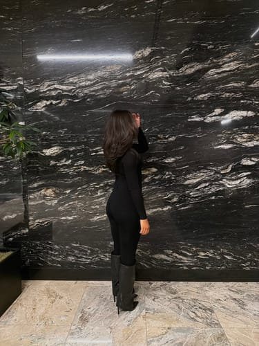 Reviewer from behind wearing the black NW Sculpt Jumpsuit, showing its form-fitting silhouette.