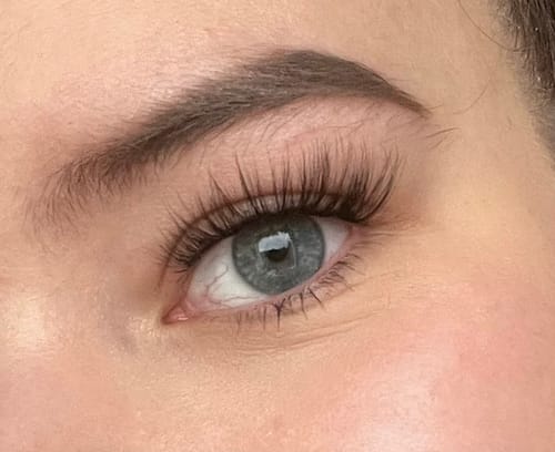 Nahaufnahme des Auges einer Kundin, das die langen, ausdrucksstarken ANTIQUE Wimpern im Cat-Eye-Stil trägt.