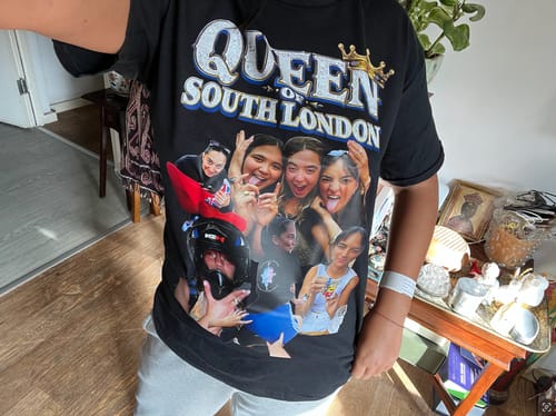 Reviewer wearing a black unisex t-shirt featuring a custom 'Queen of South London' photo collage print.