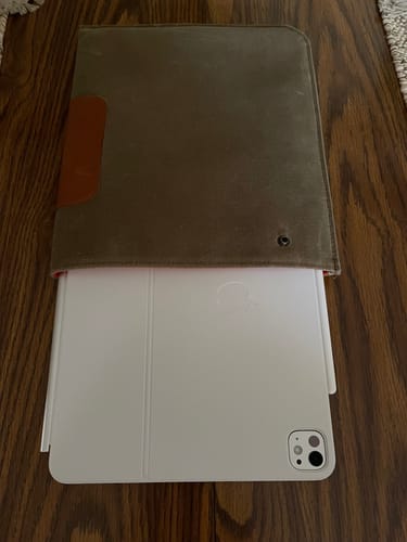Reviewer's sage Magic Keyboard Durable Sleeve with a white iPad and keyboard partially inserted, showing the orange interior.