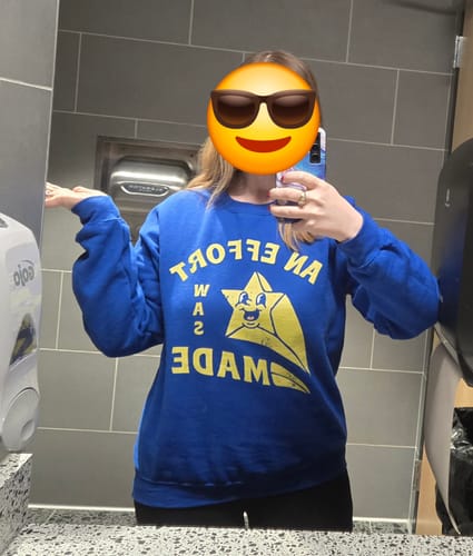 Reviewer wearing the blue An Effort Was Made Sweatshirt in a mirror selfie.