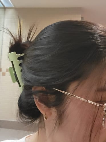 A reviewer's dark hair secured in an updo by a light green cloud clip.