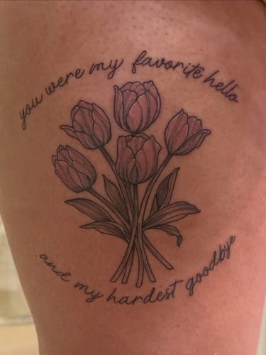Reviewer's fresh thigh tattoo of tulips and script, showing calm skin after using Painless Tattoo numbing cream.