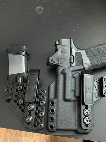 Customer's black APX holster with a handgun and extra magazine, highlighting its modular design.