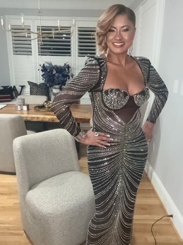 Customer standing in the Molly Black Rhinestone Maxi Dress, showing the padded shoulders and long, embellished sleeves.