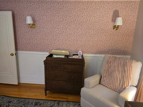 Customer's room showing the pink patterned Penelope Wallpaper installed above white wainscoting.