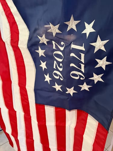 Reviewer's close-up of the Betsy Ross Flag, showing the detailed embroidery on the stars and the years 1776 and 2026.