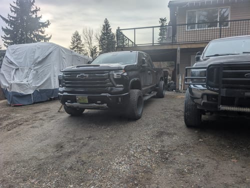 Customer's black Chevrolet truck parked in a driveway, showing a leveled stance after installing the leveling key set.