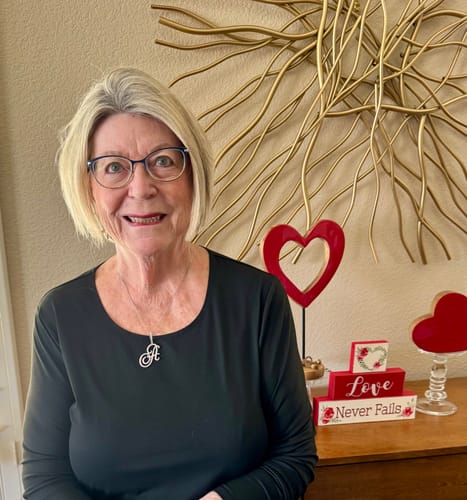 Customer wearing her white gold plated Custom Script initial 'A' necklace with a black top.