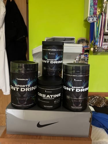 Reviewer's Creapure Creatine and Sports Drink supplements from Complex arranged on a box.