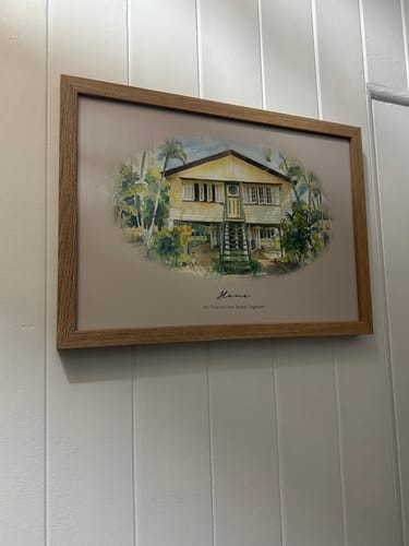Reviewer's framed Custom House Portrait in landscape orientation, hung on a white panelled wall.