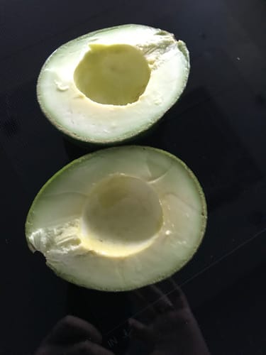 Nahaufnahme einer vom Kunden aufgeschnittenen Reed-Avocado, die das cremige, hellgrüne Fruchtfleisch zeigt.