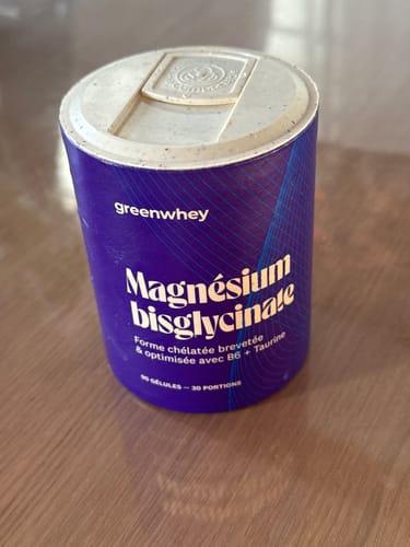 Photo d'un client montrant le pot violet de Magnésium Bisglycinate sur une table.
