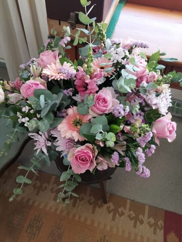 Customer's beautiful Country Garden Bouquet with pink roses, gerberas, and lush eucalyptus leaves arranged in a vase.