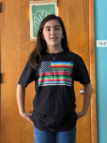 Customer wearing the black Mexcellent Old School Serape Flag T-Shirt, showing off the bright graphic.