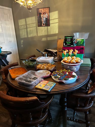 Reviewer's wizarding-themed party spread on a dining table for the murder mystery game.