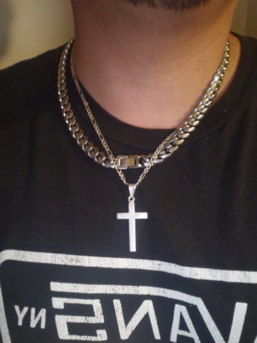 Primer plano de un cliente que lleva puesta la Cadena Cuban de 10 mm, que se ve gruesa y plateada sobre una camiseta negra.