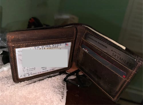 Customer's open brown leather Huron Premium Bifold, showing the ID window and card slots filled with cards.