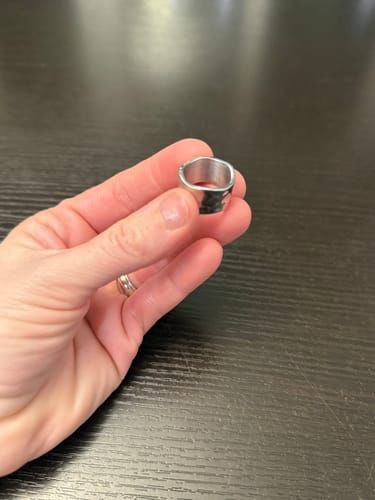 Close-up of a customer holding the Textured Band Ring to show its hammered finish.