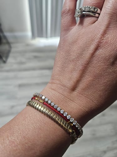 Customer's sparkly Luxe Tennis Bracelet shown on a wrist, stacked with two other bracelets.