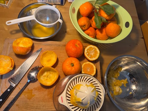 Rezensent bei der Zubereitung von Orangenmarmelade auf einem Holztisch.