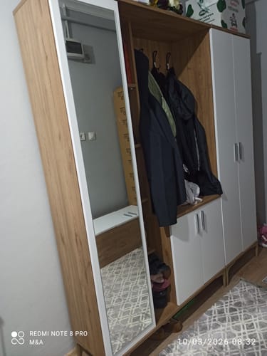 Müşterinin evinde kurulu olan ceviz ve beyaz renkli Rani EA121 portmanto, üzerinde ceketler asılı halde görünüyor.