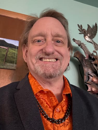 Reviewer wearing the aged Knights Templar Cuban Link Necklace over a patterned orange shirt.