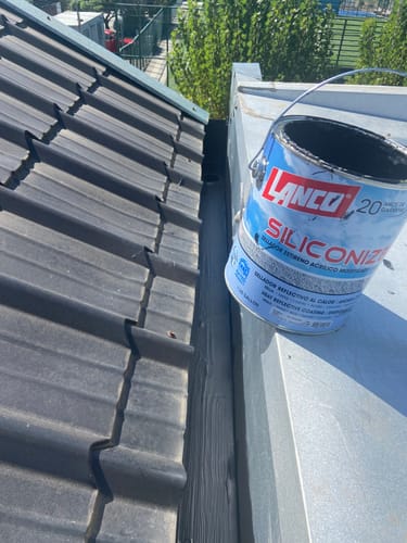 Cliente muestra el sellador de techos Lanco Siliconizer negro aplicado en la unión de un techo de tejas.