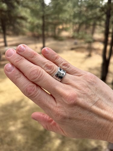 Customer's hand showing the textured silver Textured Band Ring being worn.