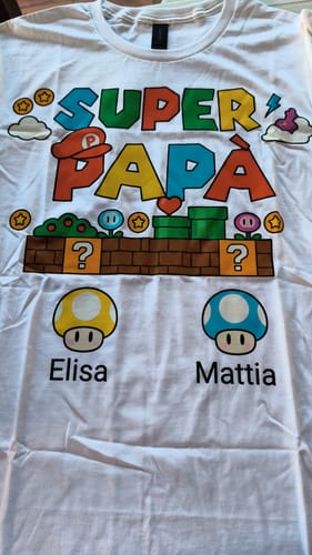 Kunde zeigt das personalisierte 'Super Papà' T-Shirt mit den Namen Elisa und Mattia im Videospiel-Design.