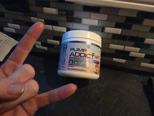 Client présentant son pot de Pump Addict Max, avec la main faisant un signe rock.