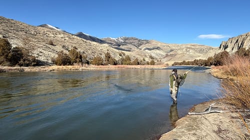 Customer fly fishing with the Redington Field Kit Trout Spey in a wide, scenic river.