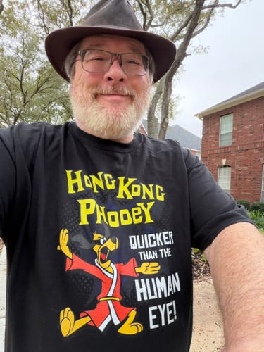 Reviewer smiling outdoors while wearing the black Hong Kong Phooey T-Shirt.