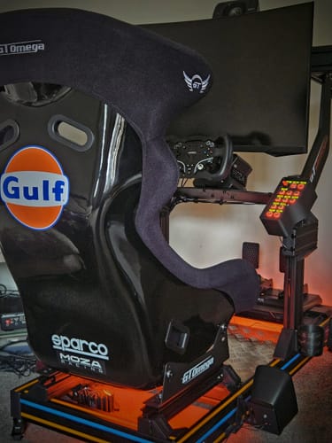Reviewer's black INERTIA Bucket Seat installed in a complete sim racing rig with a monitor and steering wheel.