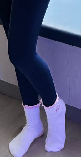 Customer wearing white socks with a pink ruffled cuff from the Bestsellers Bundle.