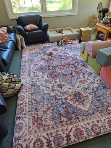 Customer's Mellow Mat in the Regalia print, spread out in a playroom with toys and couches.