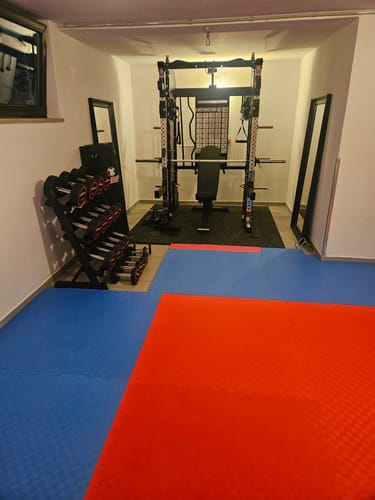 Kunde zeigt das aufgebaute Fallout Set mit Kraftstation und Hantelbank in einem Heim-Fitnessstudio.