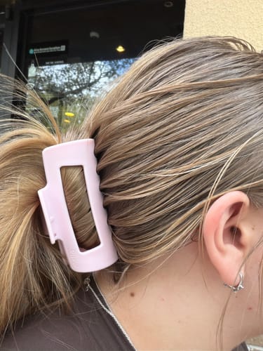 Reviewer's blonde hair held back with a light pink cloud clip.