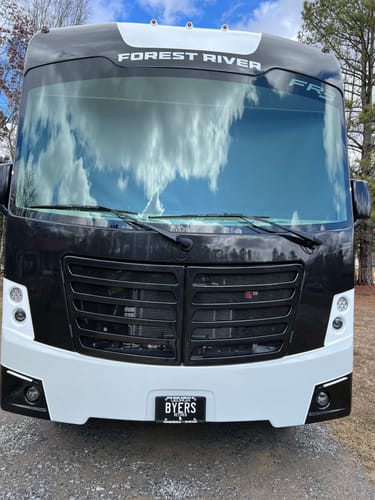 Reviewer's Georgia Blackout Metal License Plate, customized with 'BYERS', shown on the front of a motorhome.