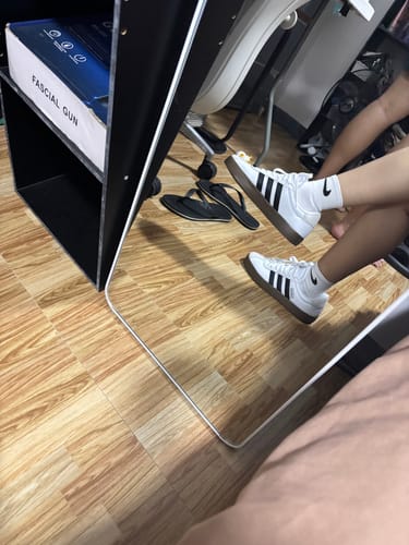 Reviewer's reflection in a mirror, wearing the white and black adidas VL Court 3.0 Lifestyle Shoes indoors.