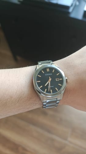 Un cliente muestra el reloj Citizen Eco-Drive en su muñeca, apreciándose la caja de acero y la esfera negra.