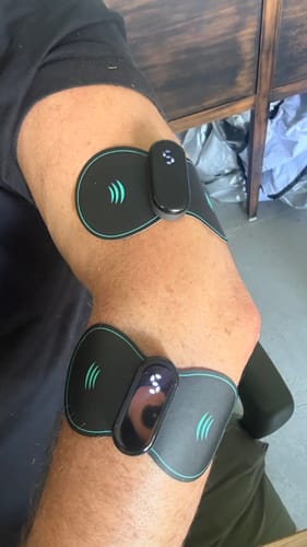Customer using two Vibit TENS devices on their arm, placed above and below the elbow.
