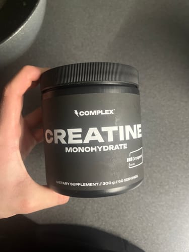 Customer holding the black tub of Complex Creatine Monohydrate.