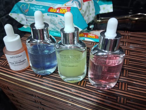 Avaliadora mostra a Solução Gaba, o frasco de líquido rosa, junto com outros produtos de skincare.