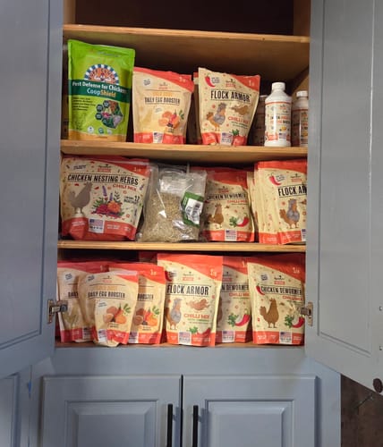 Customer's cabinet shelves fully stocked with various Roosty's chicken products, including the Nesting Herbs.