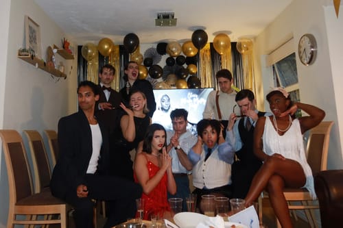 Customers in full 1920s costumes posing for a photo while playing the Murder Mystery Game Kit.