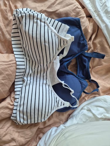 Customer's striped and navy Dorset Active Nursing Bras lying on a bed.