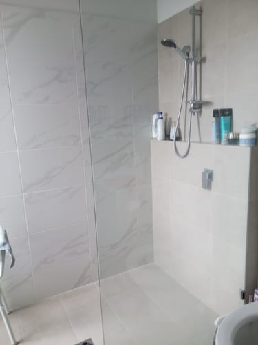 Customer's sparkling clean shower stall with shiny glass and tile, showing the results of using KoalaCloth.